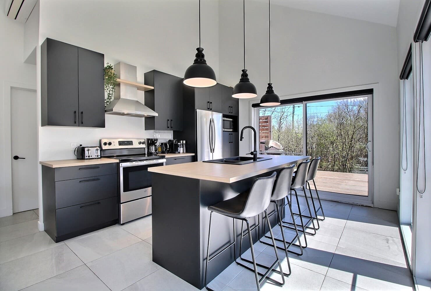Cuisine moderne noire et bois du chalet Monsieur Ferréol, îlot et électroménagers