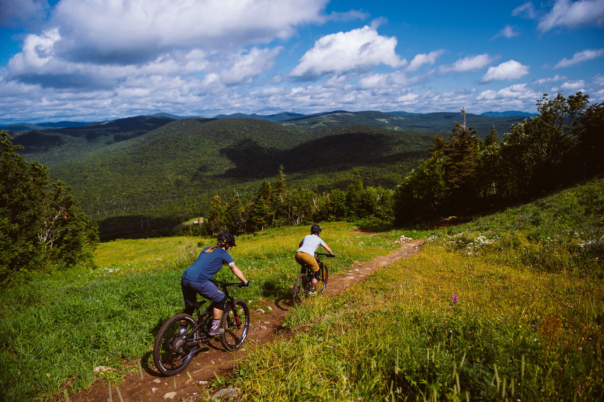 Deux riders de vélo de montagne en descente sur un sentier du Mont-Sainte-Anne